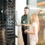 Info Tech Blogs 17 two business people standing server room with laptop discussing